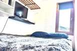 Cozy bedroom with a mounted TV and a comfortable bed.