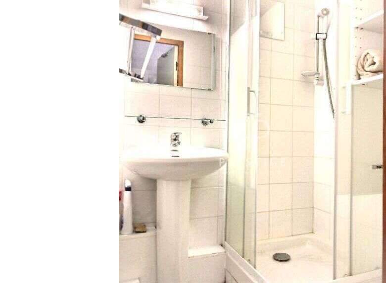 This bathroom features a sleek pedestal sink and a modern shower enclosure.