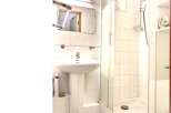This bathroom features a sleek pedestal sink and a modern shower enclosure.