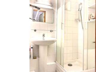 This bathroom features a sleek pedestal sink and a modern shower enclosure.