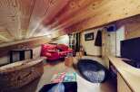 Discover the charm of this unique property, featuring a cozy living space with a distinctive sloped ceiling and exposed wooden beams.