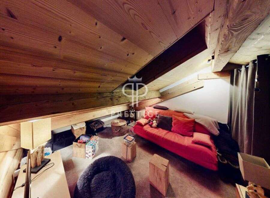 Discover the charm of this unique property, featuring a cozy living space with a distinctive sloped ceiling and exposed wooden beams.