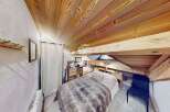 Discover the charm of this cozy bedroom with its unique wooden ceiling and exposed beams.