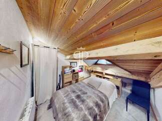 Discover the charm of this cozy bedroom with its unique wooden ceiling and exposed beams.