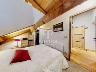 Discover the charm of this cozy bedroom, featuring a unique sloped ceiling with exposed wooden beams.
