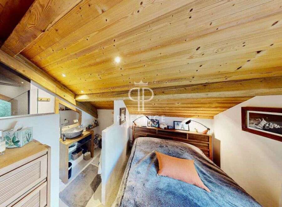 Discover the charm of this cozy bedroom with its stunning wooden ceiling and inviting ambiance.