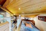 Discover the charm of this cozy bedroom with its stunning wooden ceiling and inviting ambiance.