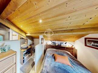 Discover the charm of this cozy bedroom with its stunning wooden ceiling and inviting ambiance.