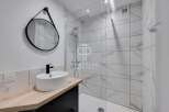 Modern bathroom design featuring a sleek round mirror and a stylish black faucet.