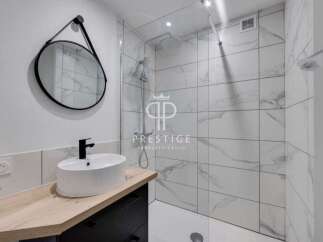Modern bathroom design featuring a sleek round mirror and a stylish black faucet.