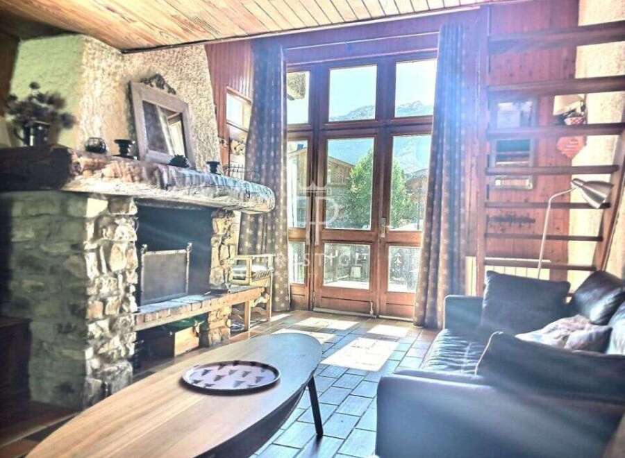Cozy up in this charming chalet featuring a rustic stone fireplace, perfect for those chilly evenings.