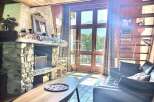 Cozy up in this charming chalet featuring a rustic stone fireplace, perfect for those chilly evenings.