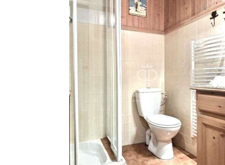 Discover a charming bathroom featuring a classic toilet and a convenient shower.