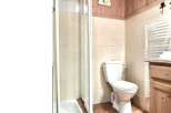 Discover a charming bathroom featuring a classic toilet and a convenient shower.