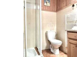Discover a charming bathroom featuring a classic toilet and a convenient shower.