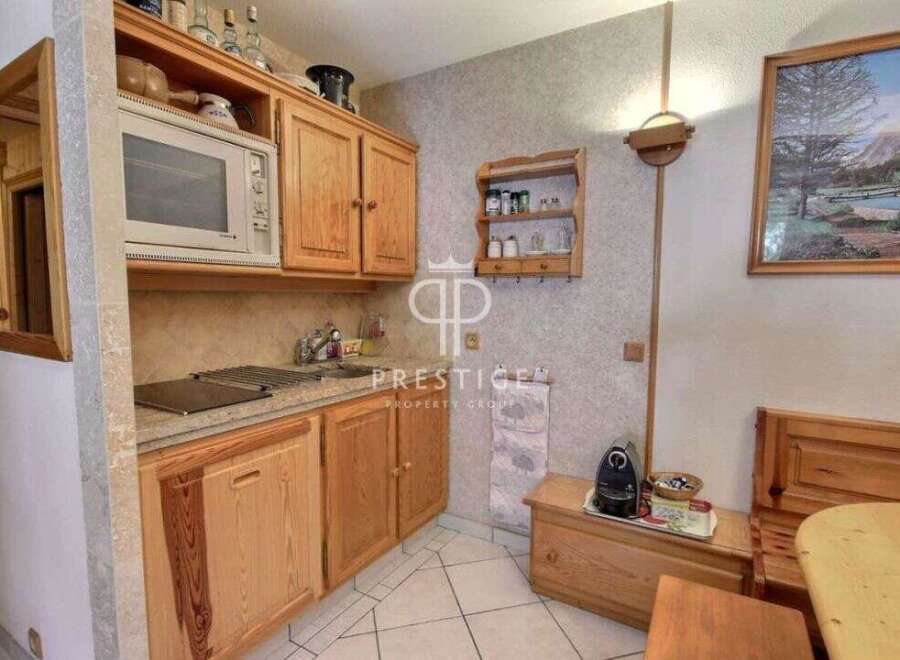 Cozy kitchen with wooden cabinets and a microwave.