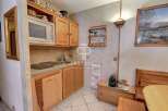 Cozy kitchen with wooden cabinets and a microwave.