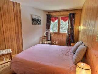 Cozy bedroom with wooden paneling and a comfortable bed.