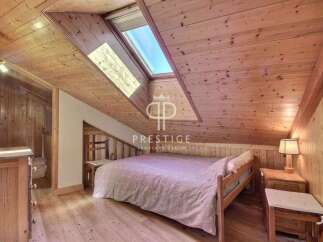 Discover the charm of this cozy bedroom with its unique wooden ceiling and walls.
