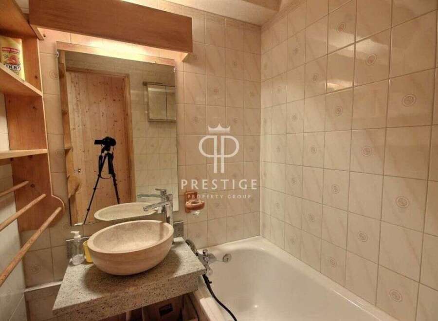 Discover a stunning bathroom with a unique stone sink and a relaxing bathtub.