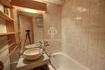 Discover a stunning bathroom with a unique stone sink and a relaxing bathtub.
