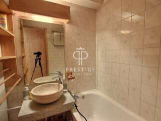 Discover a stunning bathroom with a unique stone sink and a relaxing bathtub.