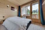 Experience the charm of this cozy bedroom, featuring warm wooden accents and a serene ambiance.