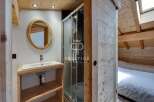 Discover the charm of this cozy bathroom, featuring a stylish wooden vanity and a sleek shower enclosure.