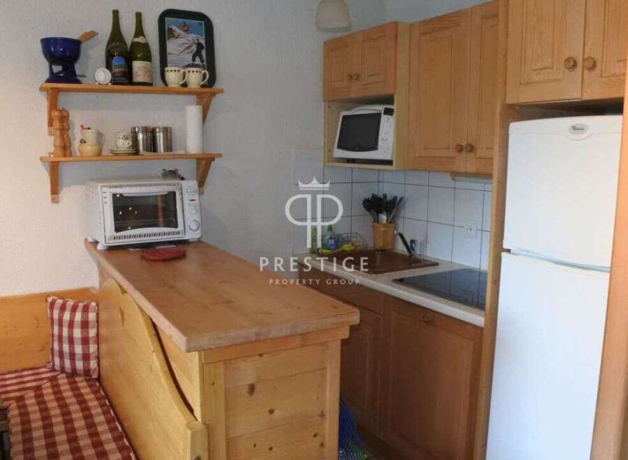 Cozy kitchen with wooden cabinets and a built-in microwave.