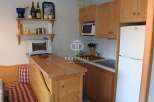 Cozy kitchen with wooden cabinets and a built-in microwave.