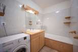 Discover a charming bathroom with a rustic wooden vanity and a convenient washing machine.