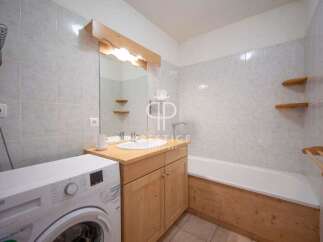 Discover a charming bathroom with a rustic wooden vanity and a convenient washing machine.