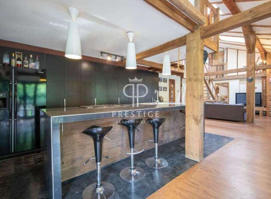 Discover luxury living in this stunning property! Featuring a modern kitchen with sleek countertops and stylish bar stools, perfect for entertaining.