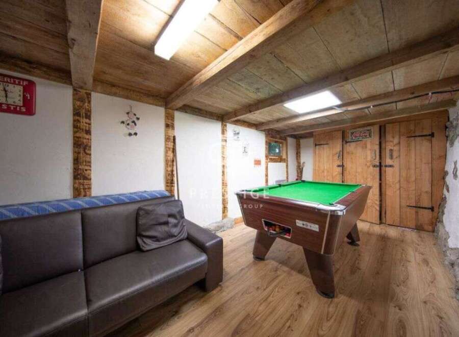 Step into this charming space featuring a cozy sofa and a classic pool table, perfect for relaxation and entertainment.