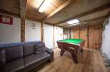 Step into this charming space featuring a cozy sofa and a classic pool table, perfect for relaxation and entertainment.