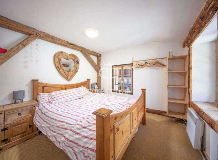 Charming bedroom with rustic wooden beams and a cozy atmosphere.