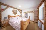 Charming bedroom with rustic wooden beams and a cozy atmosphere.