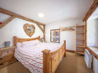 Charming bedroom with rustic wooden beams and a cozy atmosphere.