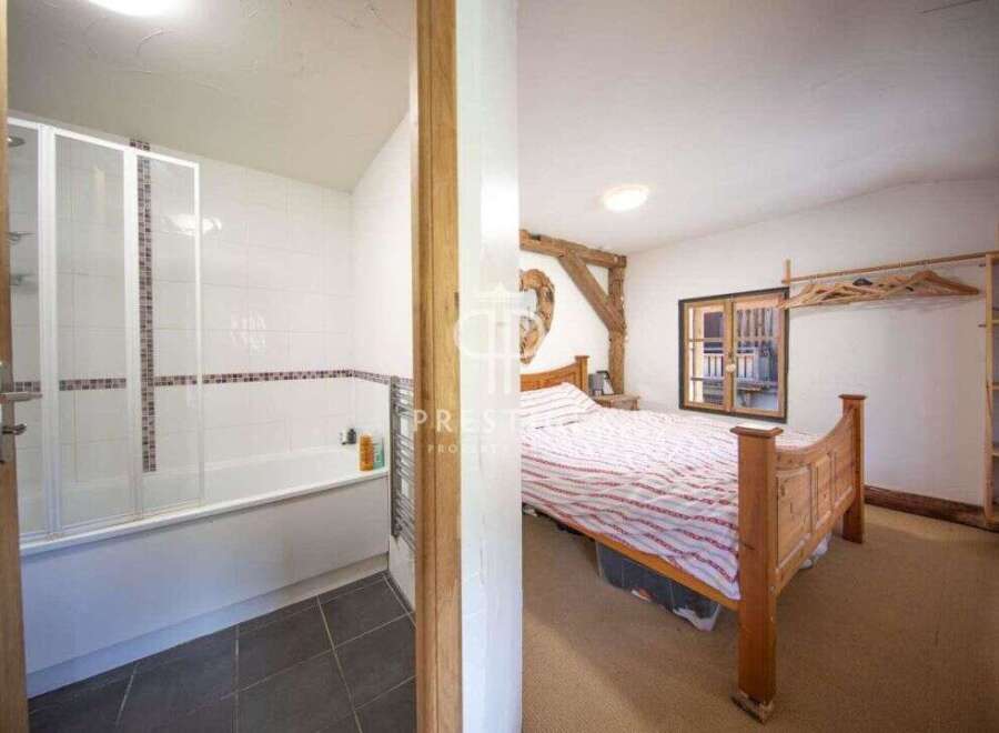 Discover the charm of this unique property, featuring a cozy bedroom with a rustic wooden bed frame.