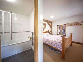 Discover the charm of this unique property, featuring a cozy bedroom with a rustic wooden bed frame.
