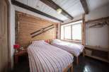 This cozy bedroom features a rustic wooden design with exposed beams and a charming ski decor.