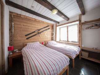 This cozy bedroom features a rustic wooden design with exposed beams and a charming ski decor.