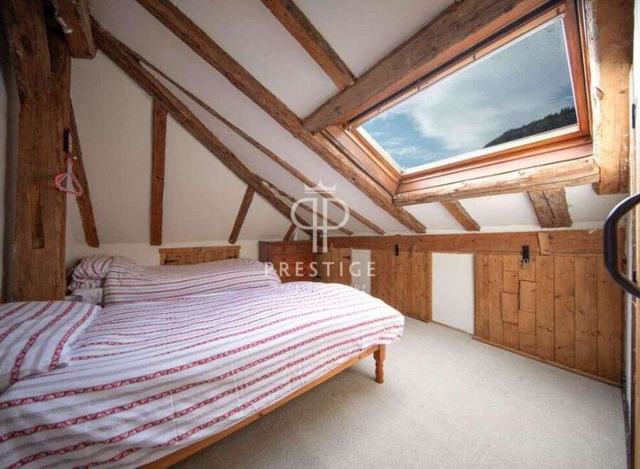 Discover the charm of this unique bedroom with exposed wooden beams and a skylight that floods the space with natural light.
