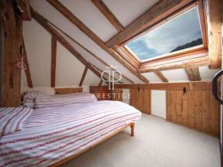 Discover the charm of this unique bedroom with exposed wooden beams and a skylight that floods the space with natural light.