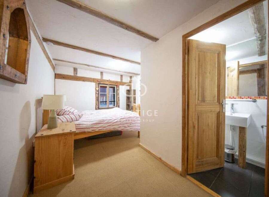 Discover the charm of this cozy bedroom with exposed wooden beams and a rustic aesthetic.