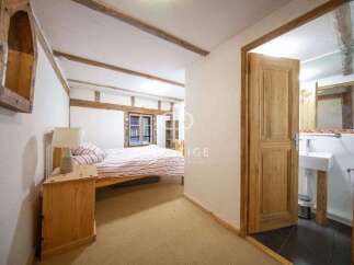 Discover the charm of this cozy bedroom with exposed wooden beams and a rustic aesthetic.