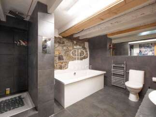 Discover the charm of this unique bathroom, featuring a striking stone wall and modern fixtures.