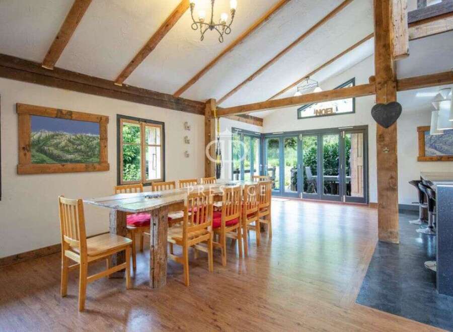 This stunning property boasts a unique dining area with exposed wooden beams and a rustic wooden table, creating a warm and inviting atmosphere.