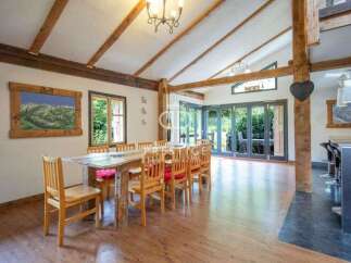 This stunning property boasts a unique dining area with exposed wooden beams and a rustic wooden table, creating a warm and inviting atmosphere.