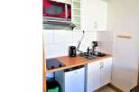 Cozy studio apartment with a compact kitchen, perfect for efficient living.